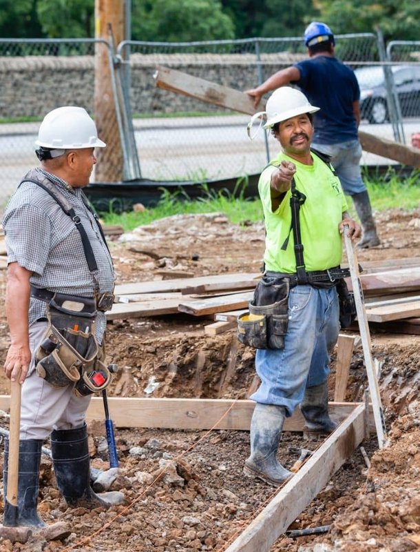 two workers laughing digging